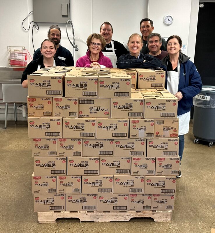 Neuenschwander Asset Management Team, clients and friends prepare meal boxes as volunteers